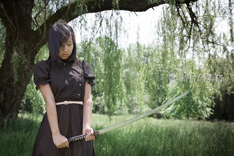 年轻的忍者女孩在夏天穿着剑