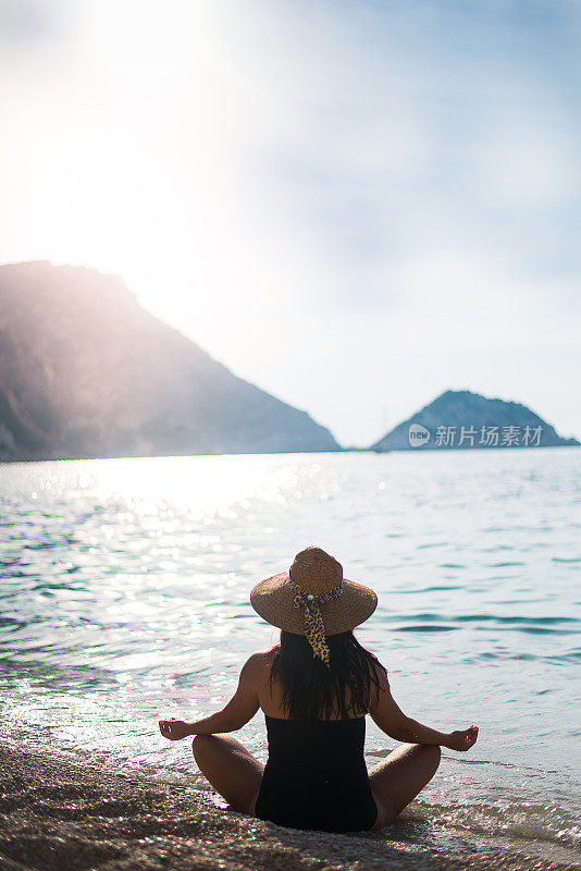 沉思的女孩在大海和夕阳的背景