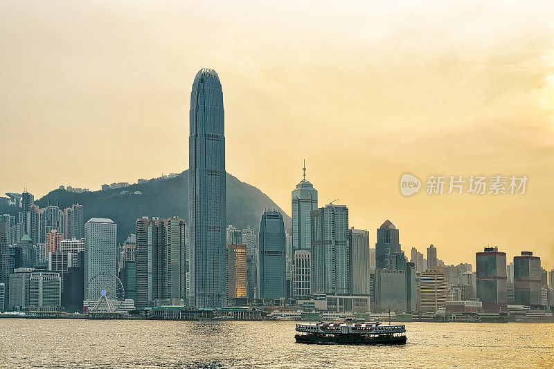 日落时分在维多利亚港的天星小轮和香港的天际线