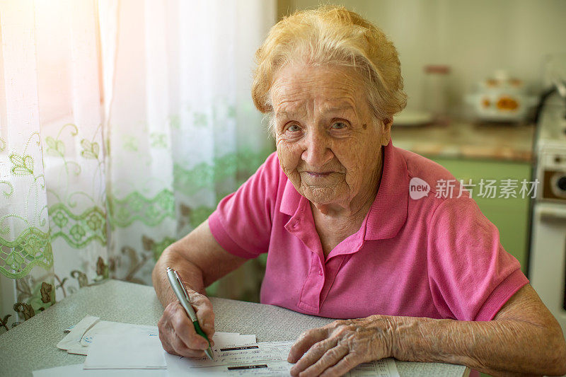 一位上了年纪的妇女填写了水电费账单。