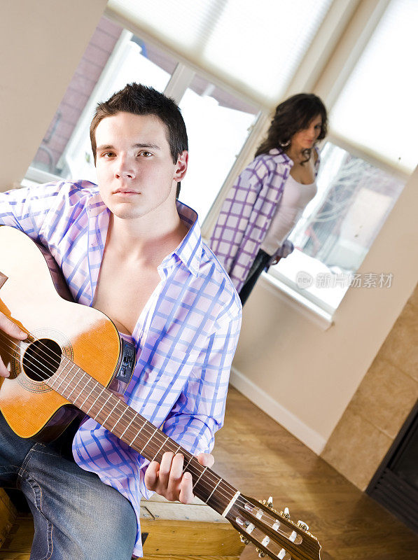 年轻男子为他身后的女友弹吉他