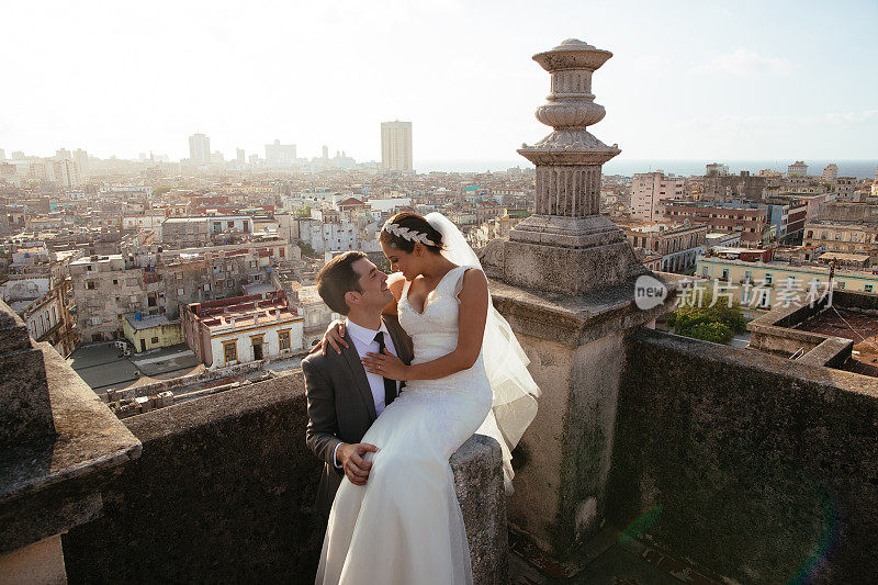 古巴哈瓦那，新郎抱着新娘在屋顶上