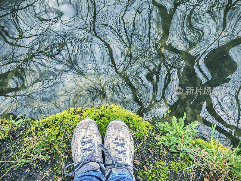 双脚站在湖岸上