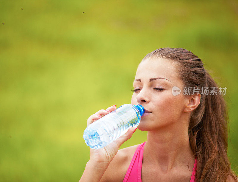 喝瓶子里水的女人