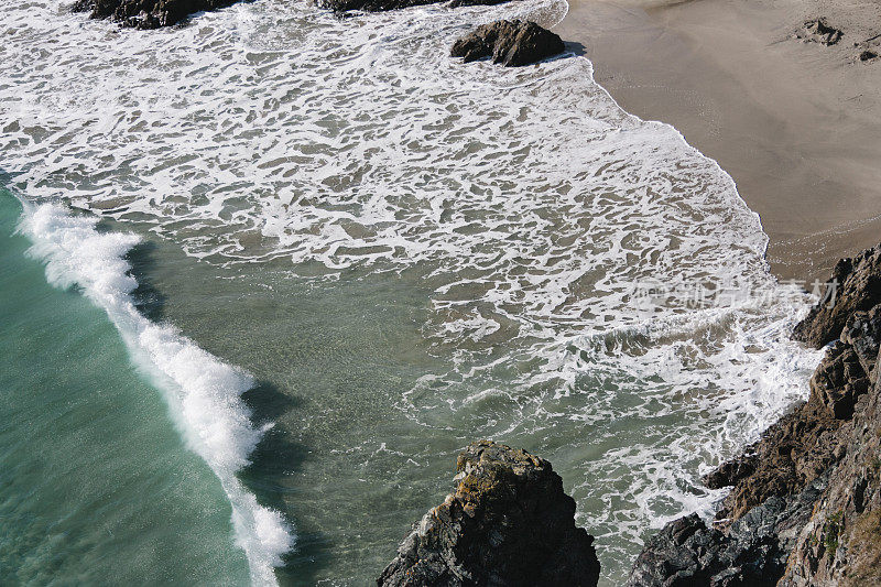 海浪冲击着岩石附近的海滩