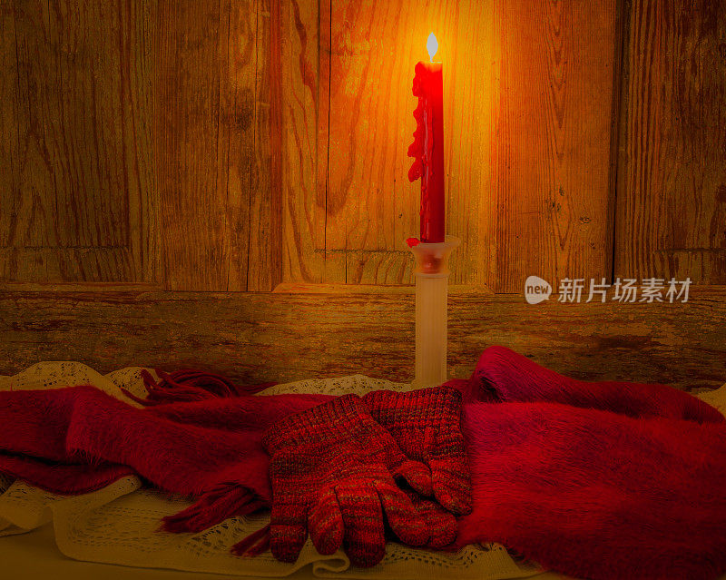 蜡烛、围巾和手套在木头的映衬下在烛光中闪烁(P)