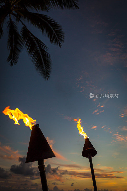 夏威夷考艾岛日落热带海滩上的火炬燃烧