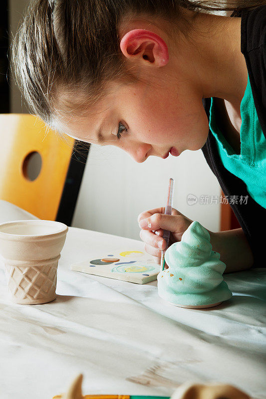 8岁白人女孩画陶器