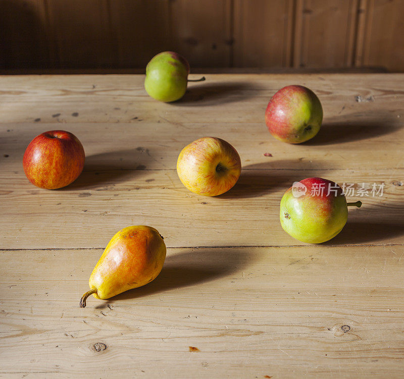 古色古香的木桌上摆着一组苹果和梨。