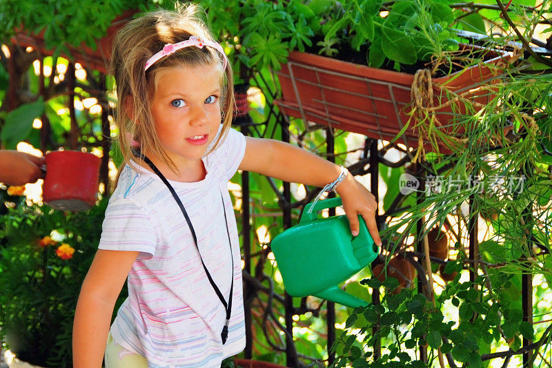 小女孩在给花园浇水