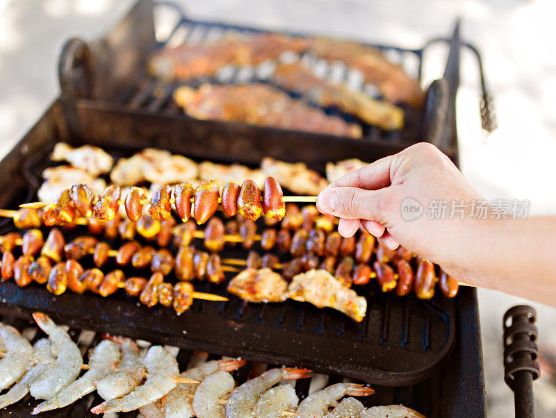 鸡心和虾肉串放在烤架上烤