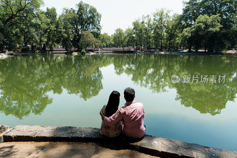 一对夫妇坐在湖边的宁静景象