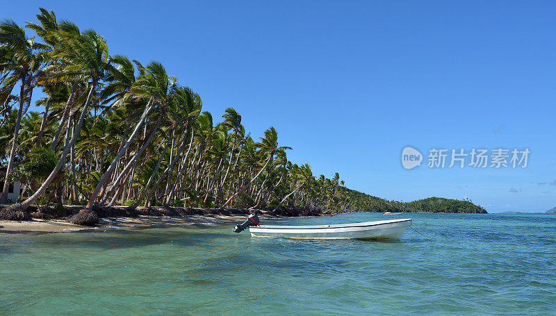 斐济热带岛屿上的白色渔船