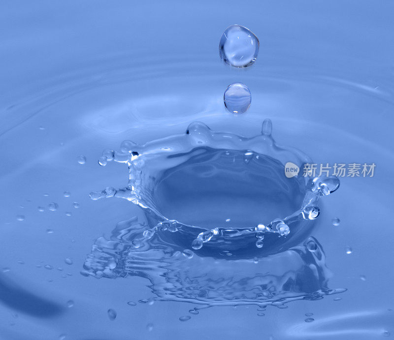 水花四溅!雨水水滴溅在蓝色池塘表面，特写