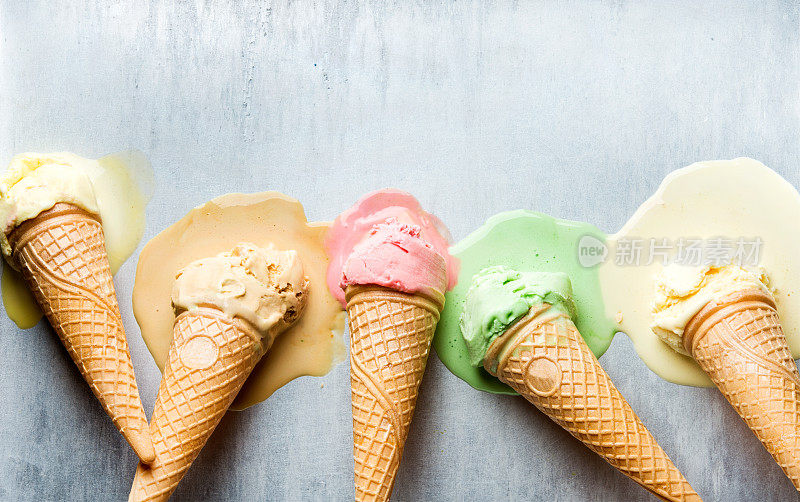 五颜六色的甜筒冰淇淋，不同的口味。融化的独家新闻。俯视图，钢金属背景