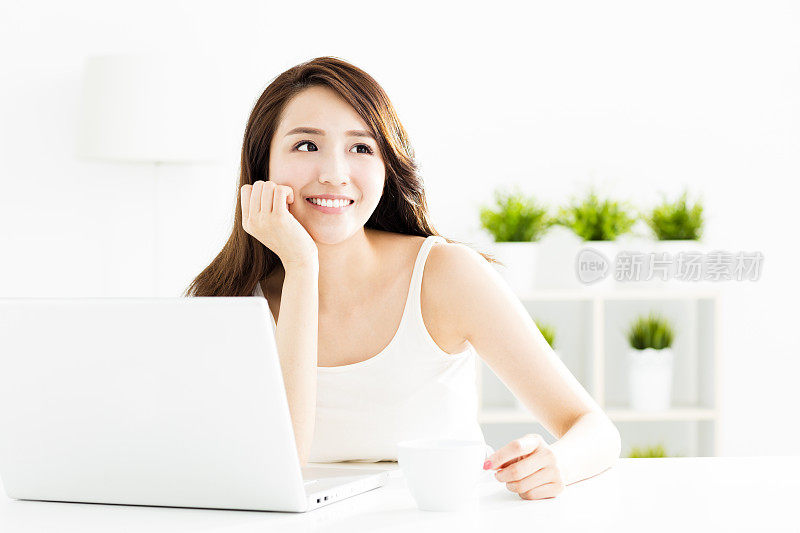 微笑的年轻女子，手提电脑在客厅