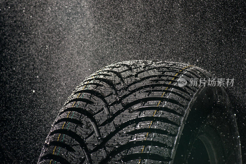 侧面的水溅在新的对称轮胎在雨中
