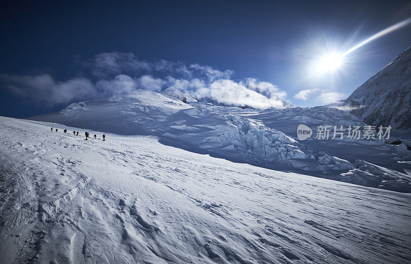 徒步旅行者拉着雪橇在西扶壁路线上的冰川上攀登德纳里山。