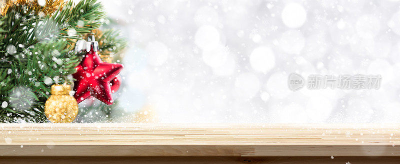 木质桌面圣诞节日横幅背景与模糊装饰松树，白色的散景和雪花在背景