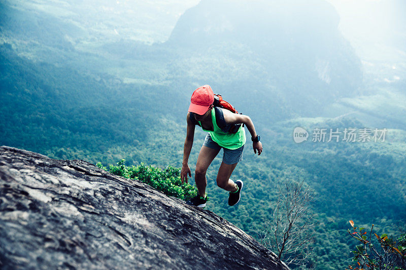 年轻的健身女士跑向山顶