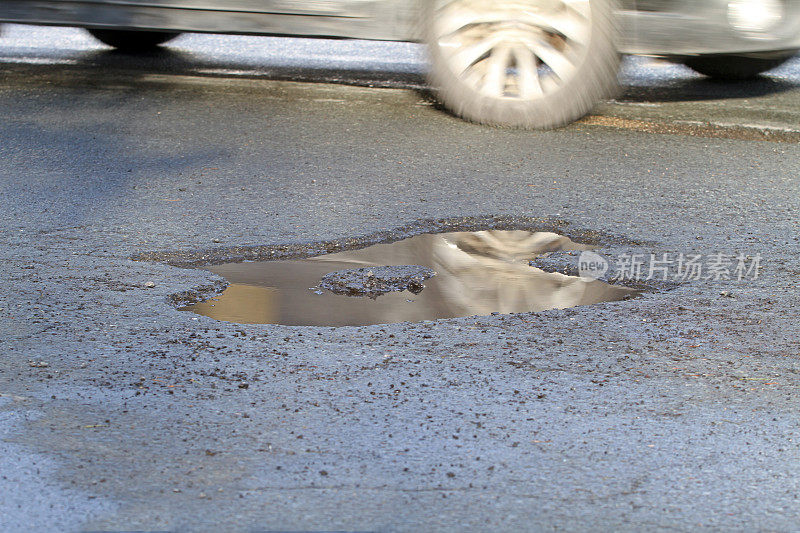 城市街道上充满水的水坑，对驾车者的危险