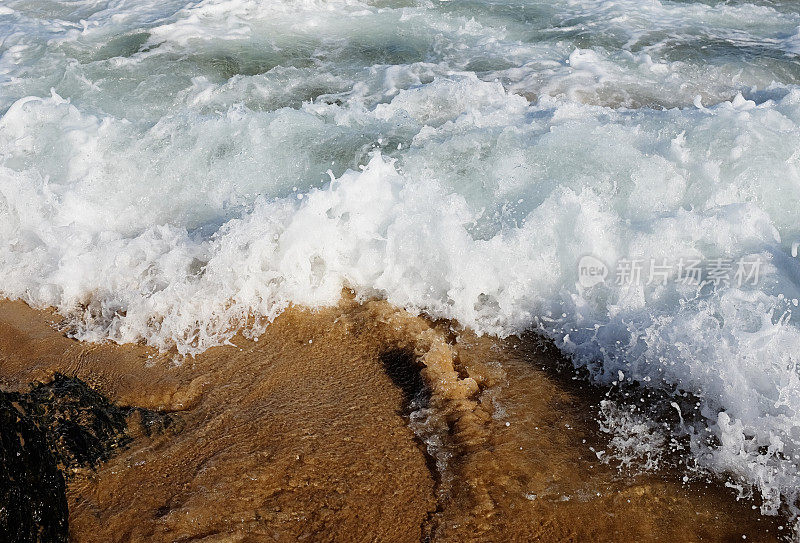 海浪拍打着有突出岩石的沙滩