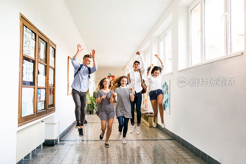 十几岁的学生在高中大厅跳得很高。