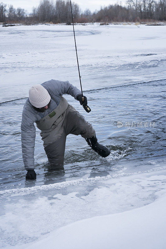 一名男子在钓鱼时从冰冷的河里冒了出来