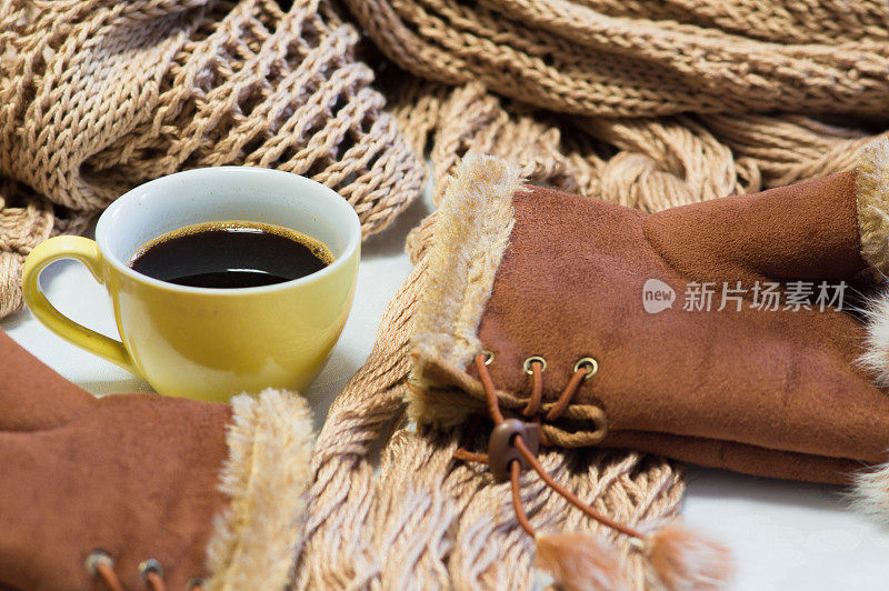 在寒冷的冬日，一杯热咖啡。暖和的围巾和手套