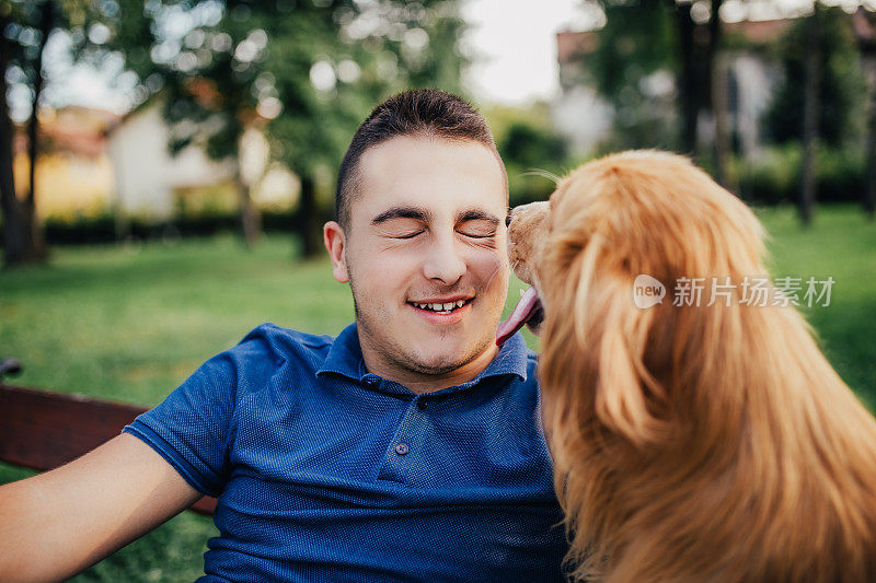 盖伊和他的狗，金毛猎犬，在城市公园。