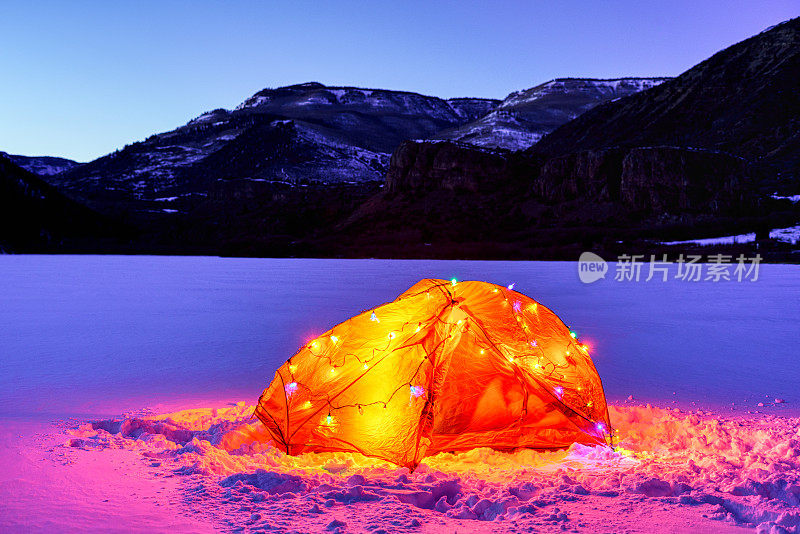 冰冻山湖上的帐篷，挂着圣诞彩灯
