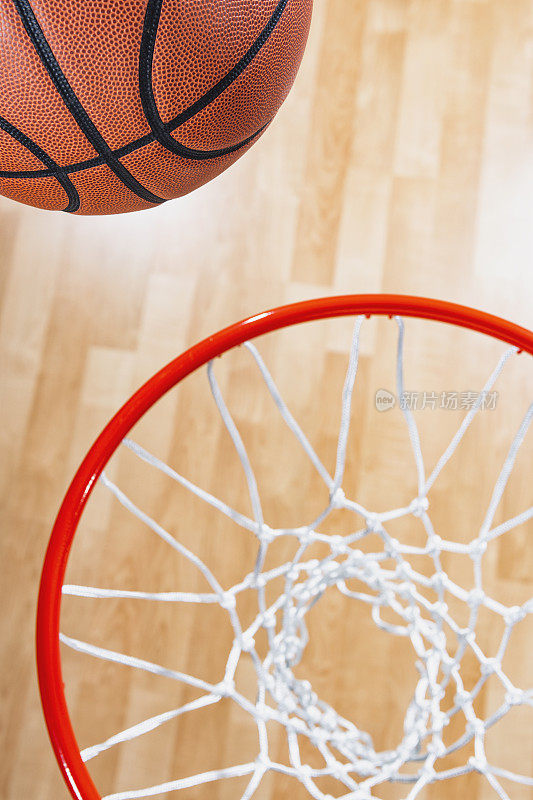 俯视着一个几乎在球馆木地板背景下的篮球网