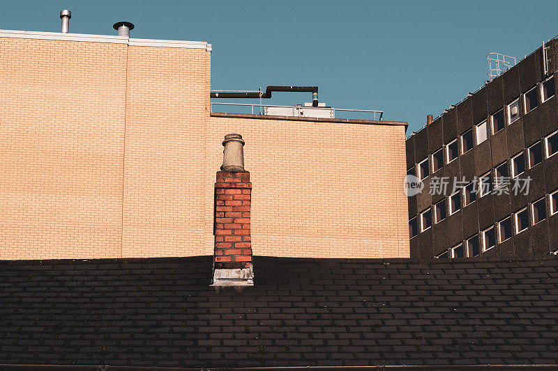 维多利亚式露台的瓦片屋顶和烟囱，现代办公室的外墙