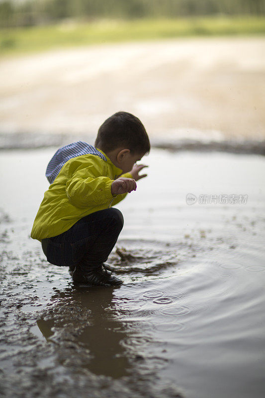 孩子们在泥泞的水坑里玩耍