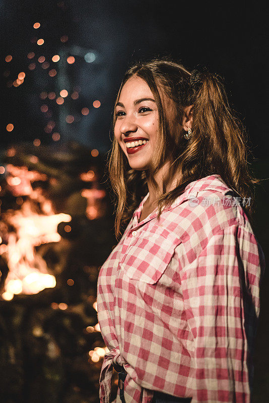 年轻女子格子衬衫服装派对朱尼纳附近的篝火