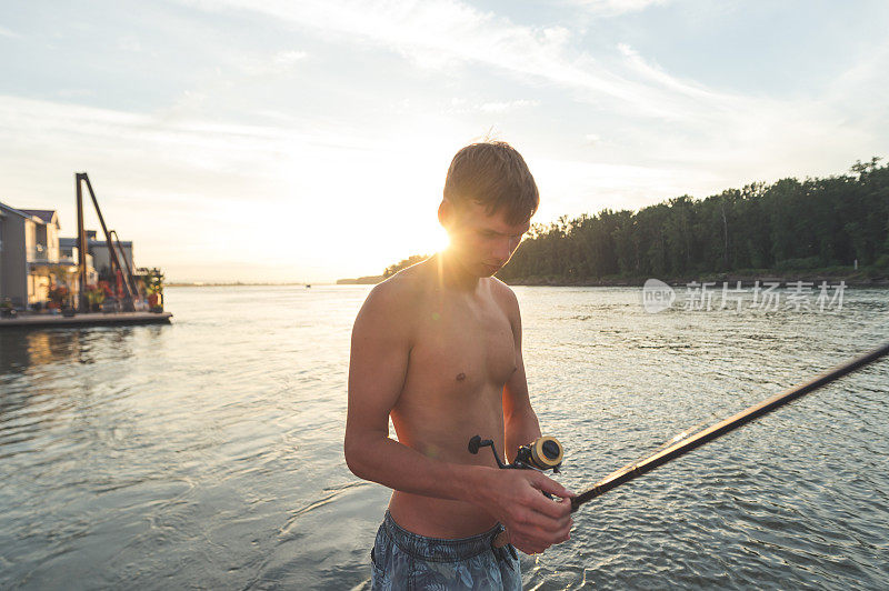 一个十几岁的男孩在河里钓鱼
