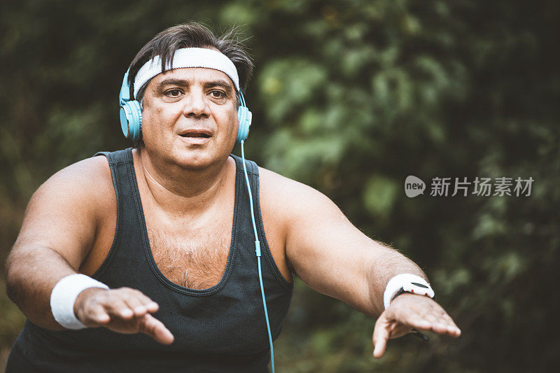 胖子积极的男人选择健康的生活方式，在公园锻炼，减肥。