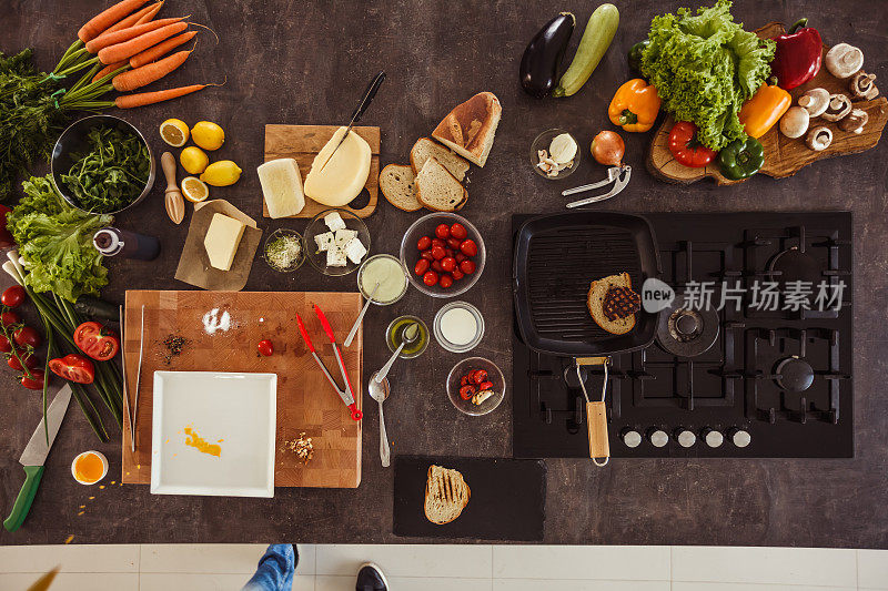 平铺的桌子上有烹饪牛排的原料和用具