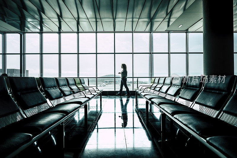 女人走在机场门口等待航班开始为商务或度假活动-航班延误或取消-权利和保险的旅客概念