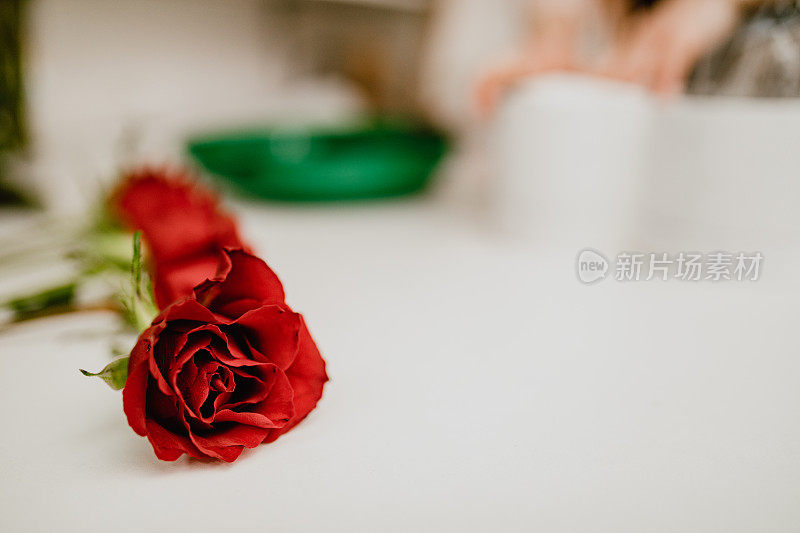花店的白桌上放着红玫瑰