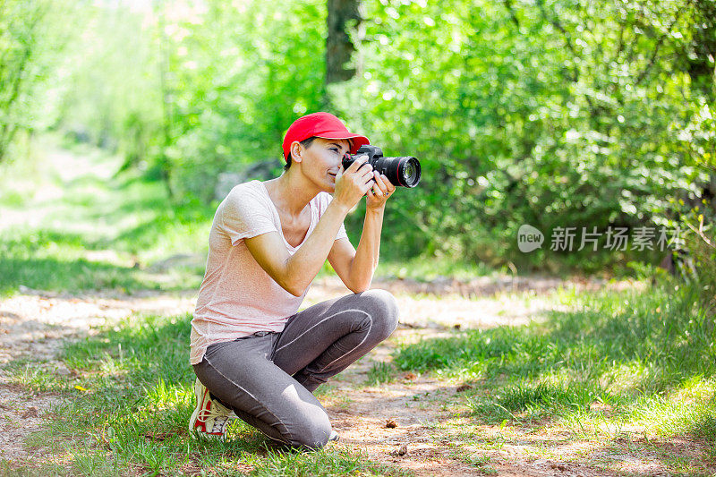 中年妇女摄影师在森林