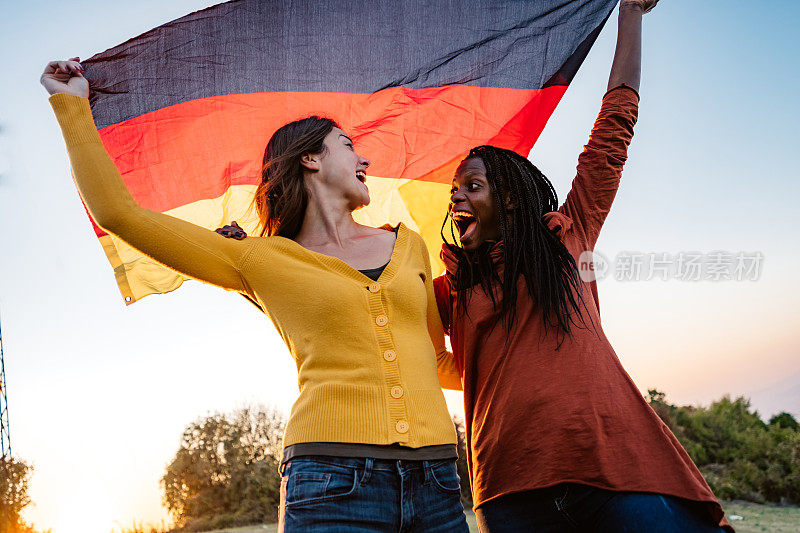 两名多民族妇女举着德国国旗