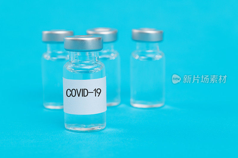 以蓝色为背景的Covid-19疫苗瓶