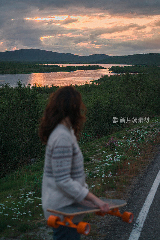 芬兰的一名女子在路上玩长滑板