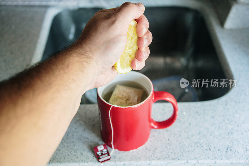 在茶杯上挤柠檬汁