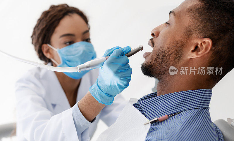非洲女牙医在给病人钻孔，特写