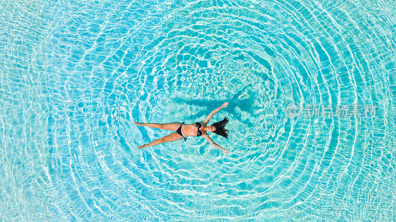 鸟瞰图，一个女人放松漂浮在水里