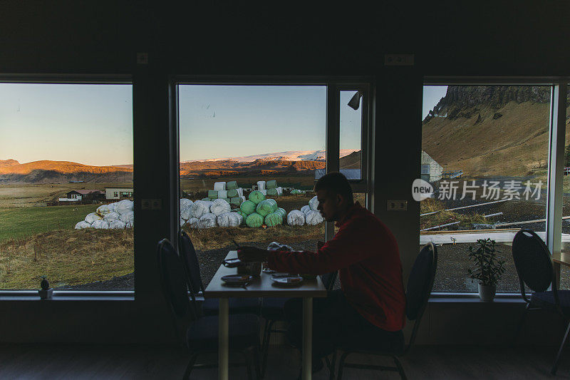 一名游客在享用早餐的同时欣赏冰岛的全景