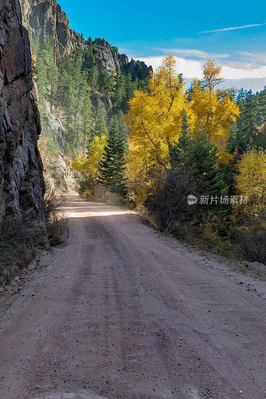 秋天在狭窄，崎岖的泥土路通过落基山峡谷