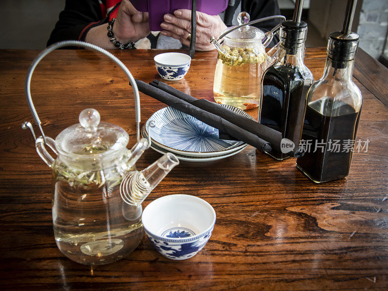 亚洲玻璃茶壶和陶瓷杯盘，筷子和调味品。